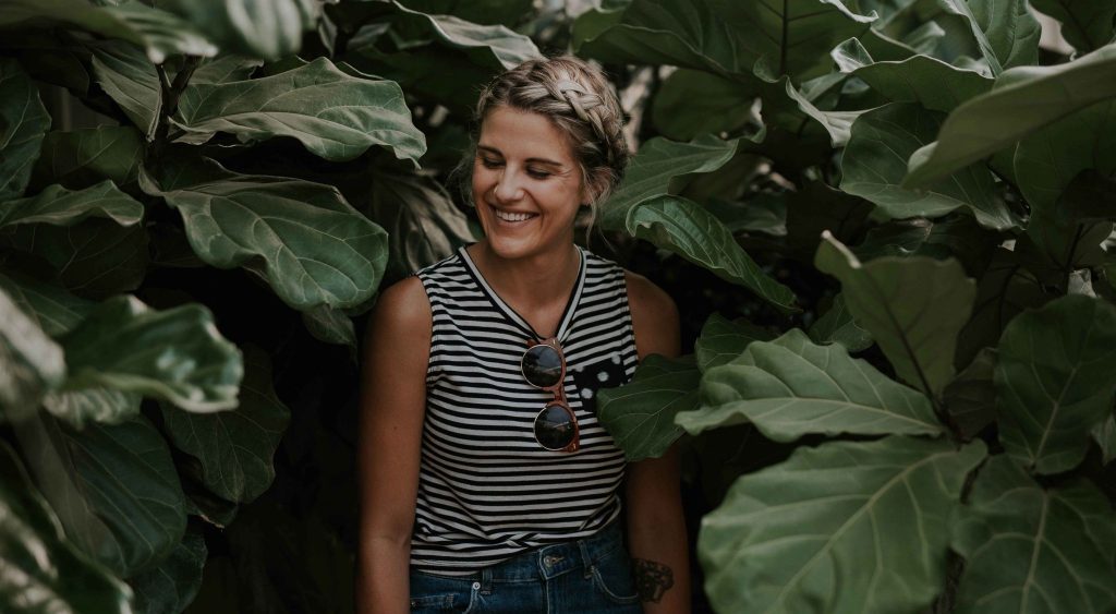 Woman happy smiling standing against greenery